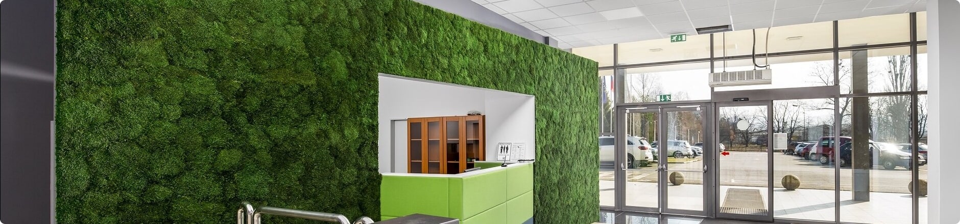 eine grüne Wand mit einer Tür und einem Fenster darin und eine grüne Graswand dahinter und ein Metallhandlauf, moosbild, mooswand, moos pflanzen, moos, moos deko, moos art