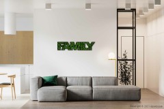 ein Wohnzimmer mit einer Couch und einem Tisch, darüber an der Wand ein Familienschild, moosbild, mooswand, moos pflanzen, moos, moos deko, moos art