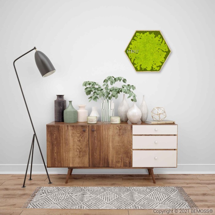 ein Raum mit einer Kommode und einer Lampe darauf und einer grünen sechseckigen Wand darüber, moosbild, mooswand, moos pflanzen, moos, moos deko, moos art